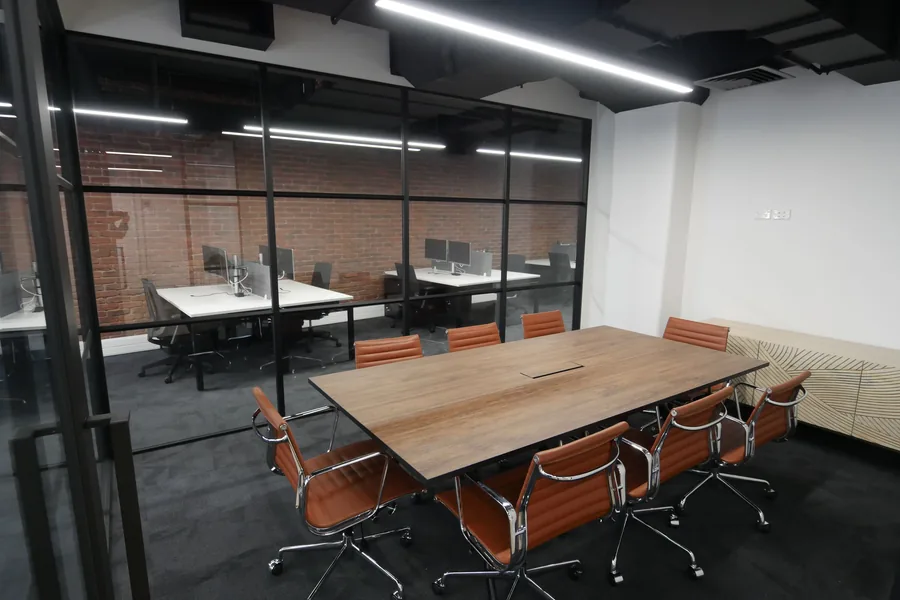 A Pāua Wealth Management workspace with a patterned screen and meeting chairs