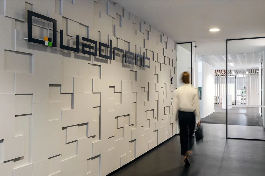 The sculptured white brand wall in Quadrent’s office, with their logo mounted on it